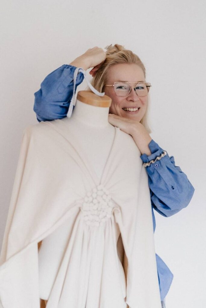 Frau stütz sich auf Schneiderpuppe