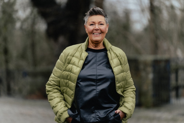Portrait einer Frau in grüner Jacke in der Natur